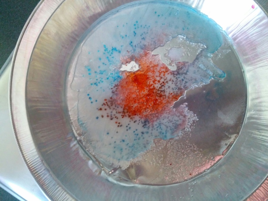 Put some water in a shallow pan and place it in the freezer. When it has frozen hard, take it out and sprinkle it with salt. As it starts to melt, brush some food color over the ice so you can see the salt and holes melting in the ice better. (Photo: Susan Jeppesen, Weber County Library)