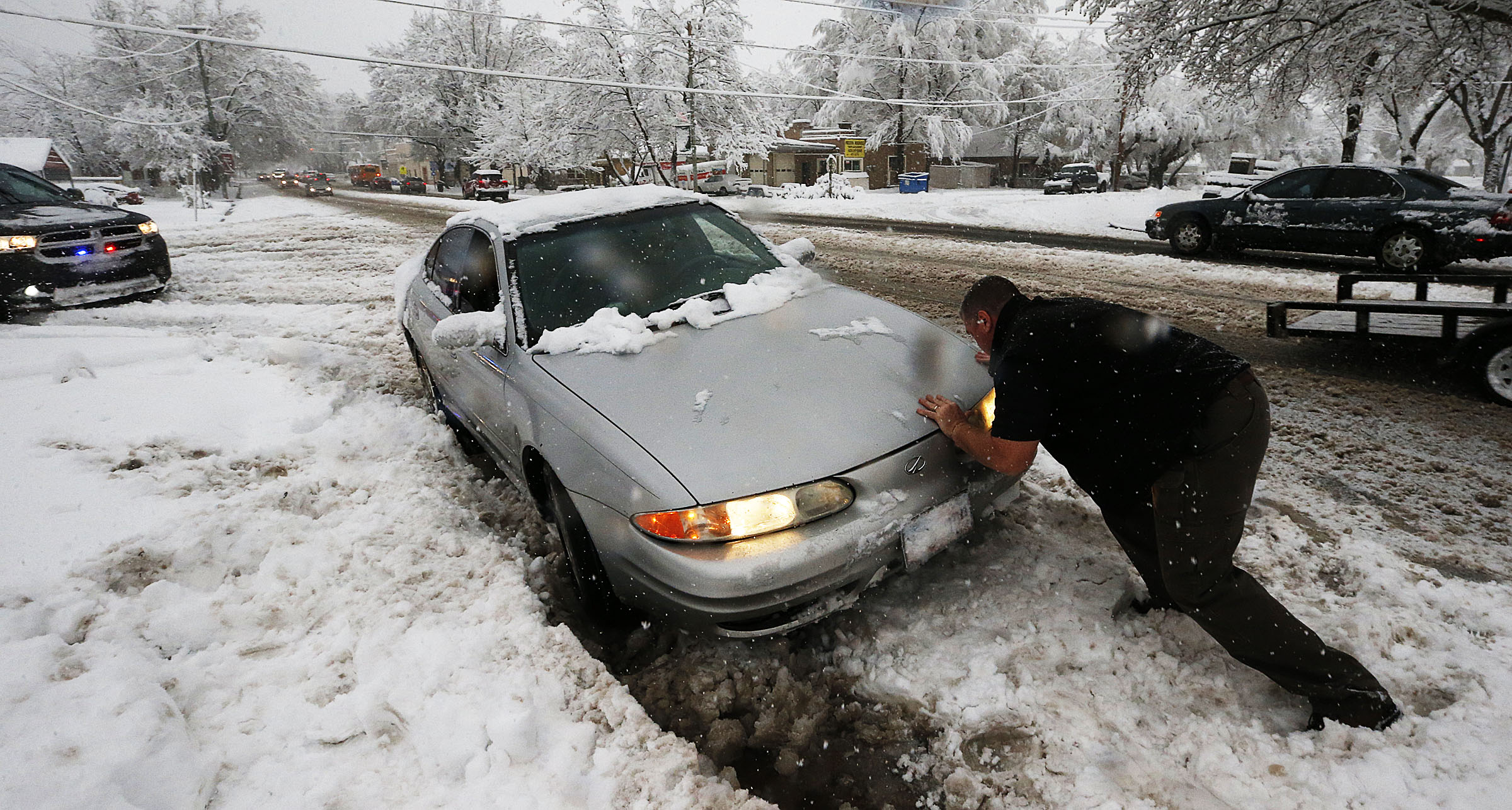 An officer helps free a car stuck on Main Street in Farmington, Dec. 14, 2015. When it comes to getting teen drivers prepared for the emergencies that can arise on Utah's streets and highways, the message is the same: You have to talk about it.