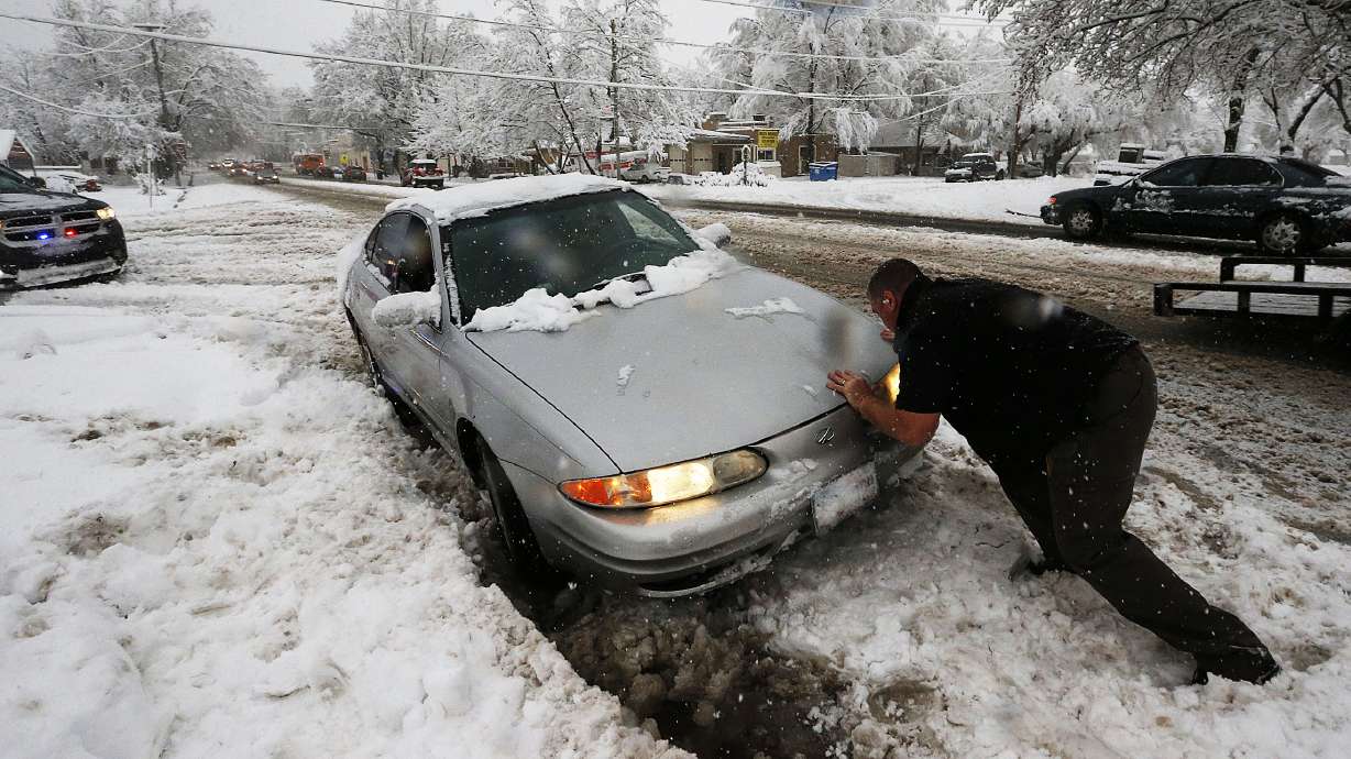 An officer helps free a car stuck on Main Street in Farmington, Dec. 14, 2015. When it comes to getting teen drivers prepared for the emergencies that can arise on Utah's streets and highways, the message is the same: You have to talk about it.