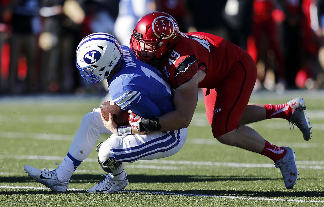 BYU quarterback Tanner Mangum (12) is sacked by Utah defensive end Hunter Dimick (49) during NCAA football at the Royal Purple Las Vegas Bowl, Dec. 19, 2015. (Photo: Ravell Call, Deseret News)