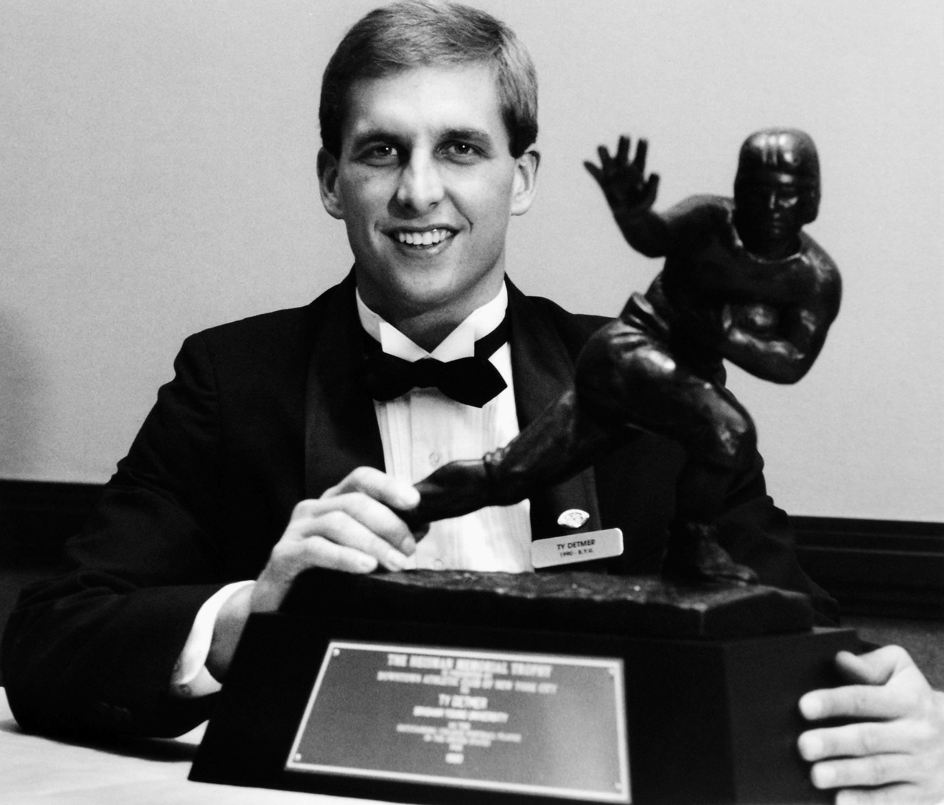 Former quarterback Ty Detmer, shown here with the Heisman Trophy he won in 1990, will be named the next offensive coordinator at BYU. (AP Photo)