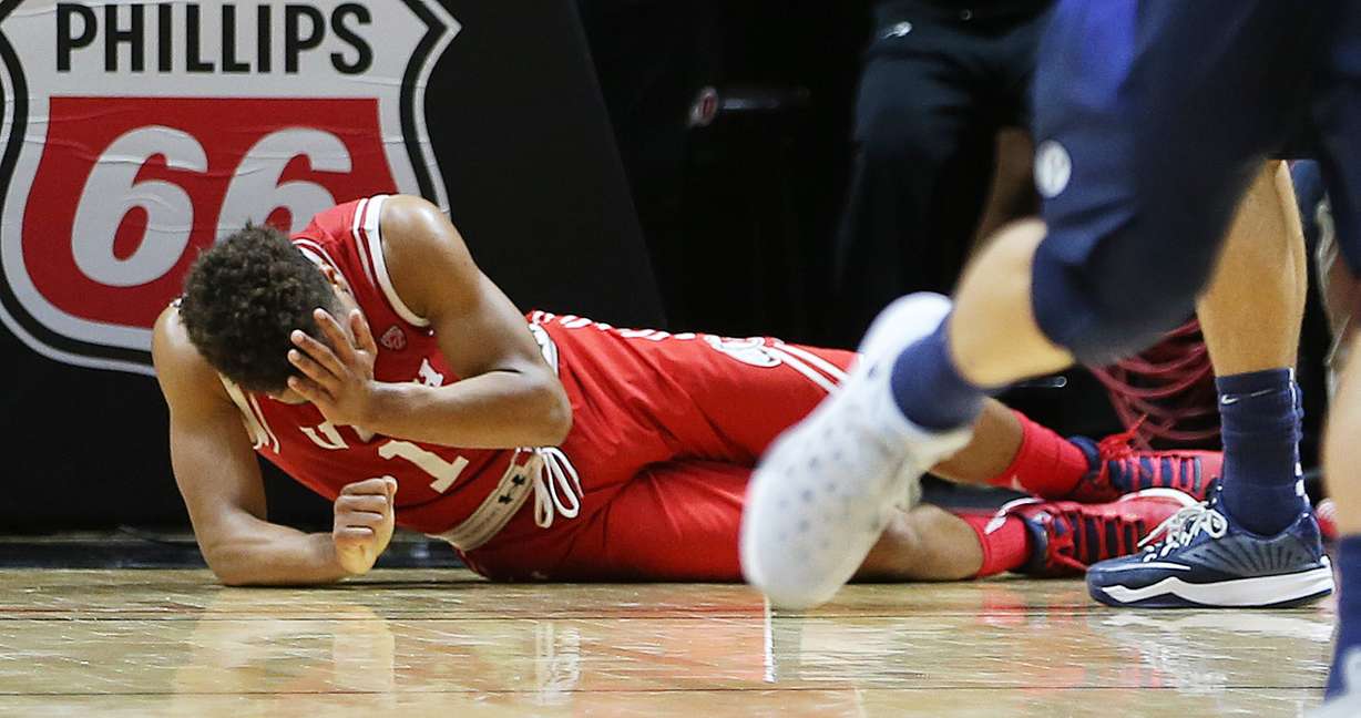 Utah Utes guard Brandon Taylor (11) holds his face after being hit by Brigham Young Cougars guard Nick Emery (4) as Utah and BYU play in the Huntsman Center in Salt Lake City Wednesday, Dec. 2, 2015. Utah won 83-75. (Photo: Scott G. Winterton/Deseret News)