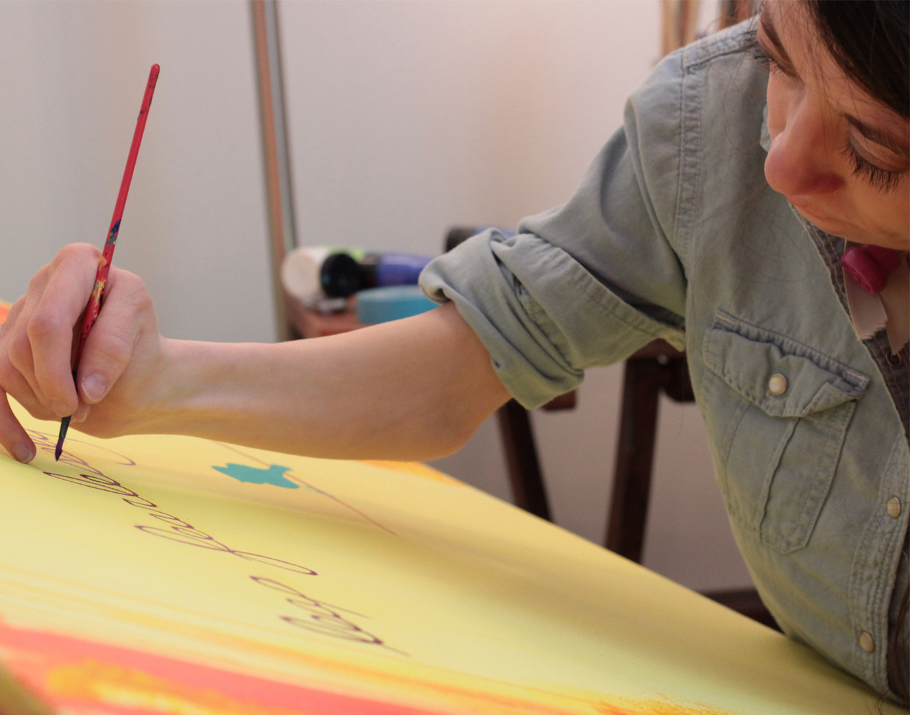 Kelie Babcock uses color and texture to create her optimistic images. Nature often inspires her work. Here, she works on a painting. (Photo: Kelie Babcock)