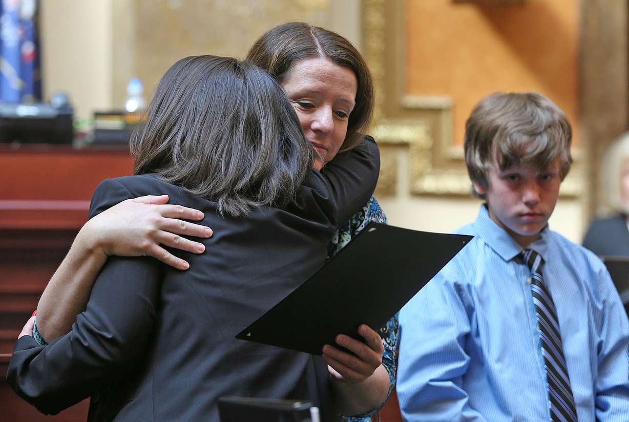 Rep. Angela Romero, D-Salt Lake City, hugs Erika Barney, the widow of fallen Unified police officer Doug Barney, who was killed in the line of duty last month, as their son Jack, looks on. Barney and officer John Richey, who was injured in the shootout on Jan. 17, 2016, were honored in the Utah House of Representatives at the Capitol in Salt Lake City on Tuesday, Feb. 16, 2016. (Photo: Tom Smart/Deseret News)