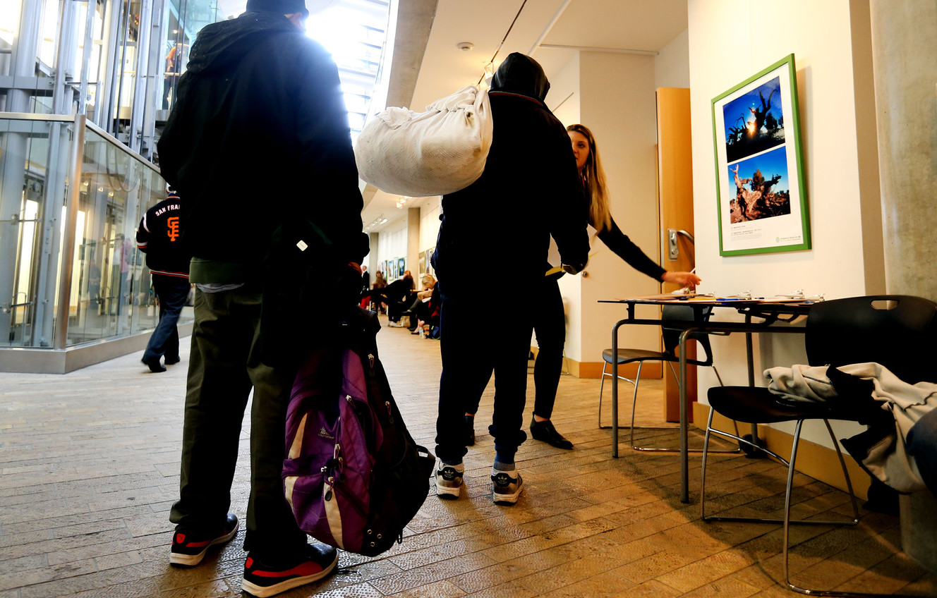 People wait in line to get a free flu shot and a slice of pizza at the Salt Lake City Public Library on Thursday, Feb. 18, 2016. Thanks to a vaccine donation from SelectHealth, the Salt Lake County Health Department made free flu shots available for uninsured people over age 3. (Photo: Laura Seitz, Deseret News)