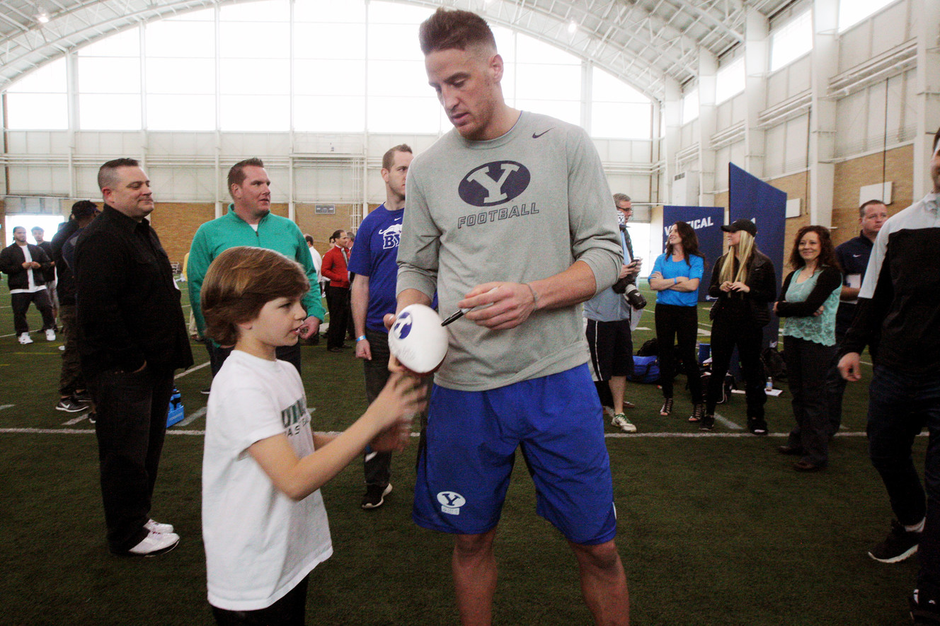 Mitch Mathews signs a football for Beau Bierman as BYU football players participate in Pro Day at their indoor practice facility in Provo Friday, March 25, 2016. (Photo: Scott G Winterton, Deseret News)