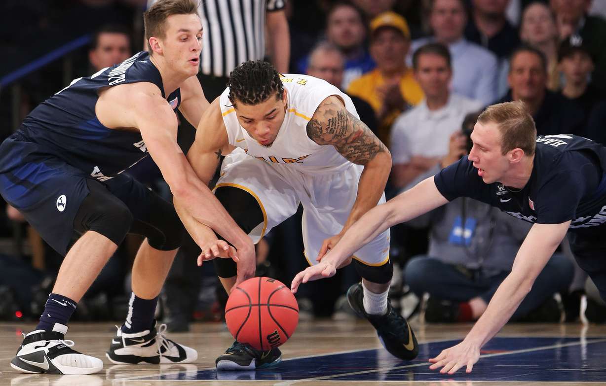BYUs guard Kyle Collinsworth (5) and BYU forward Jakob Hartsock (34) try to take the ball from Valparaiso guard Tevonn Walker (2) as BYU and Valparaiso play in NIT Semifinal action at Madison Square Garden in New York City Tuesday, March 29, 2016. (Photo: Scott G Winterton, Deseret News)