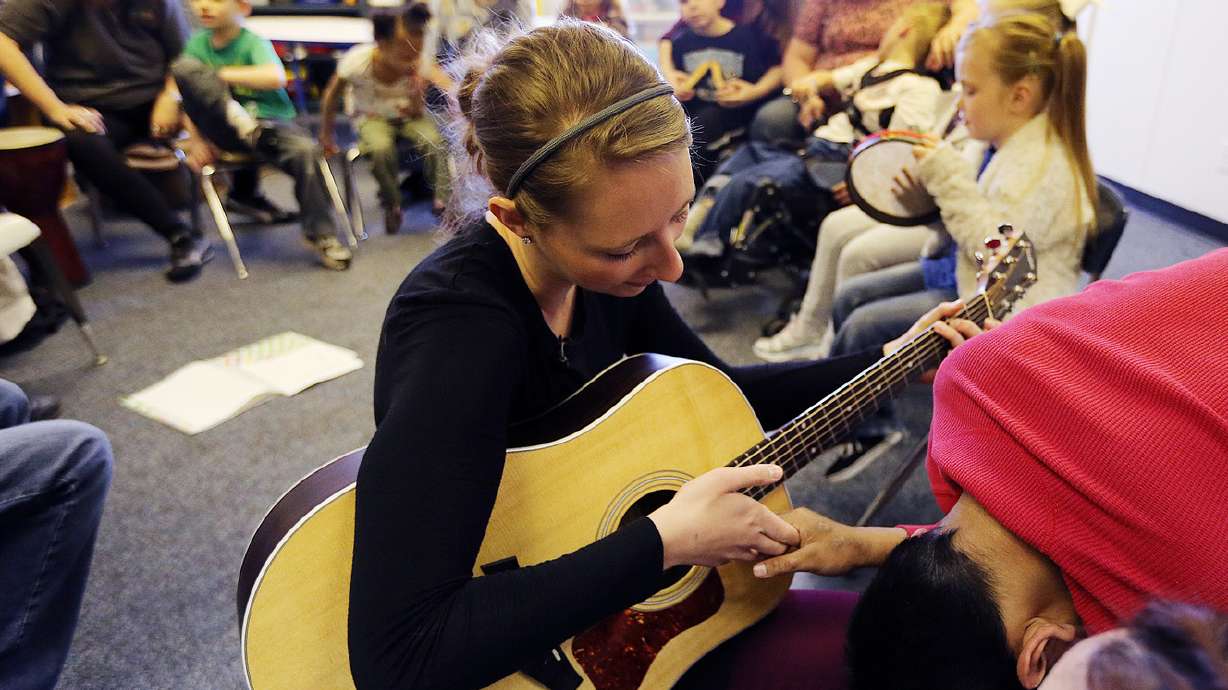Board-certified music therapist Rachel Lighty helps a student play the guitar during a music therapy class at the Millcreek campus of the Utah Schools for the Deaf and Blind in Salt Lake City on April 5, 2016. Beginning in the spring, the University of Utah will host a "suite" of classes for those interested in Creative Arts Therapy.