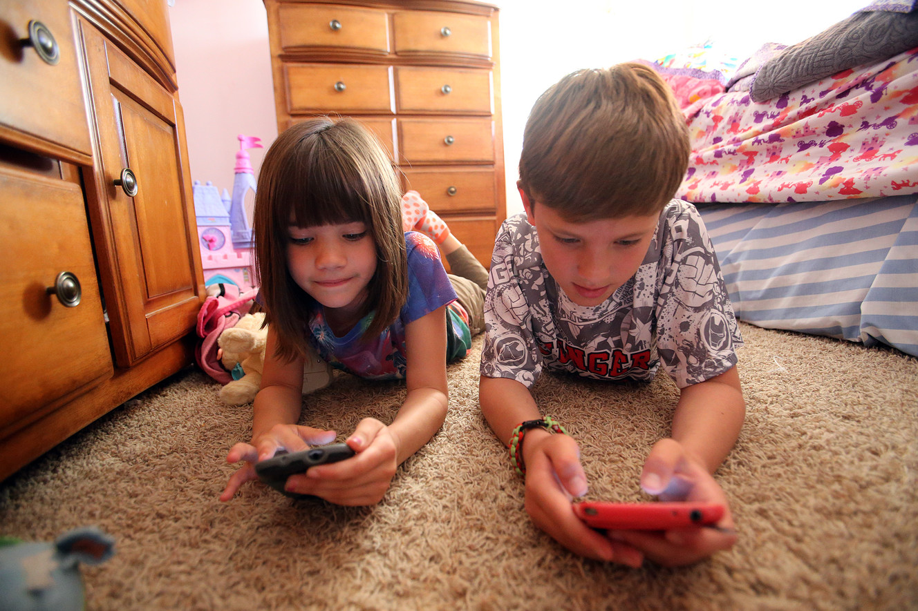 Krysti Crandall, 7, left, and Isaak Crandall, 9, play games on their parents' cellphones at their home in Lehi on Tuesday, April 26, 2016. (Photo: Chris Samuels, Deseret News)