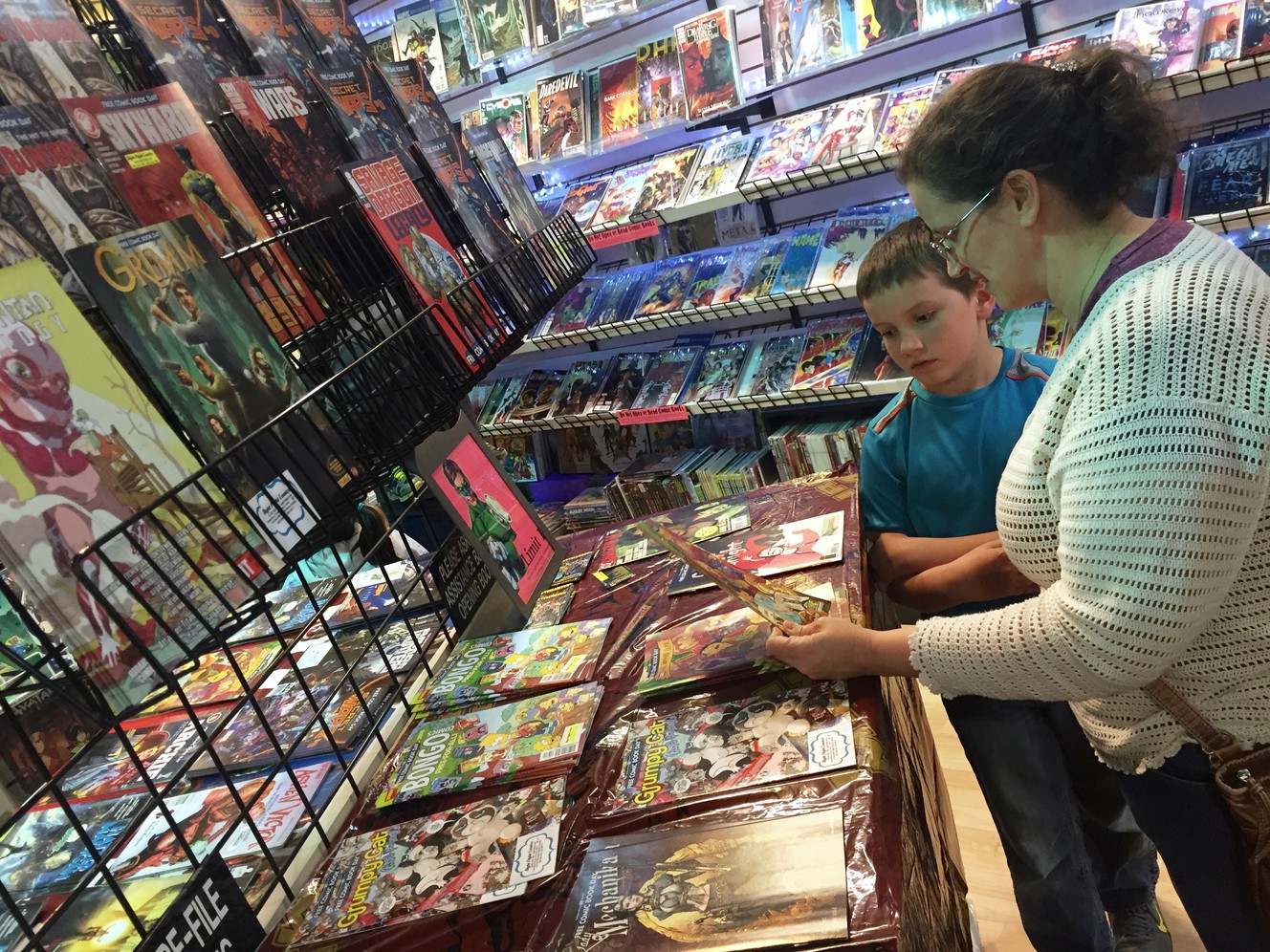 Jennifer Broschinsky and her son, Ian, peruse comic books at Night Flight Comics in Murray during Free Comic Book Day, Saturday, May 7, 2016. (Photo: McKenzie Romero, Deseret News)