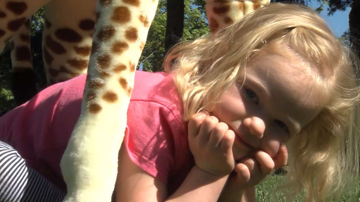 Three-year-old Ruby Thackeray hopped behind her mother, who carried a giant stuffed giraffe outside to play. Ruby's bright spirit and sunny blonde hair bely her circumstances. But some friends make you want to reach higher, like Ruby's new pal, Gerald the giraffe.