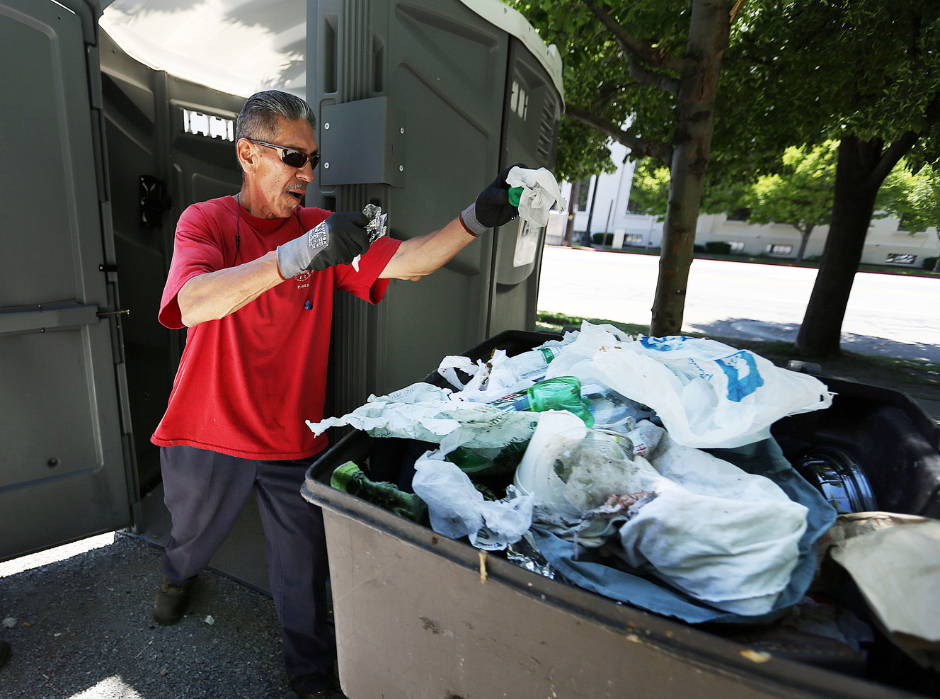 Chris Fernandez with Salt Lake City Parks cleans a portable restroom at Pioneer Park in Salt Lake City on Wednesday, June 1, 2016. Photo Credit: Ravell Call, Deseret News.