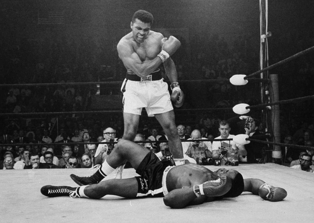 Heavyweight champion Muhammad Ali stands over fallen challenger Sonny Liston, shouting and gesturing shortly after dropping Liston with a short hard right to the jaw on May 25, 1965, in Lewiston, Maine. (AP Photo/John Rooney)