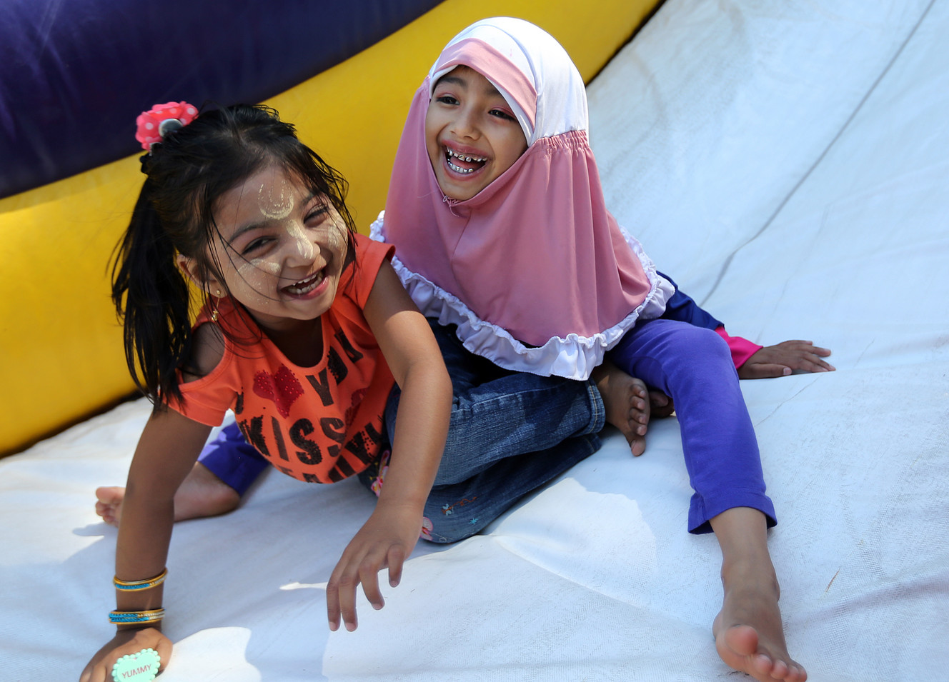 Children laugh as they play on an inflatable slide during festivities marking World Refugee Day at Liberty Park in Salt Lake City on Saturday, June 4, 2016. (Photo: Chris Samuels, Deseret News)
