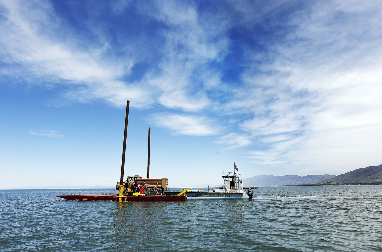 A barge carrying a dump truck floats on the water at Willard Bay on Thursday, June 9, 2016. The Utah Division of Wildlife Resources used the barge and dump trucks to place boulders in Willard Bay to enhance fish habitat. (Photo: Ravell Call, Deseret News)