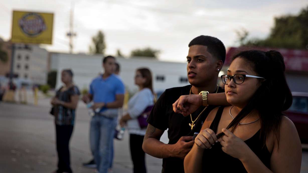 The Latest: 'We remember them': Victims' names read at vigil