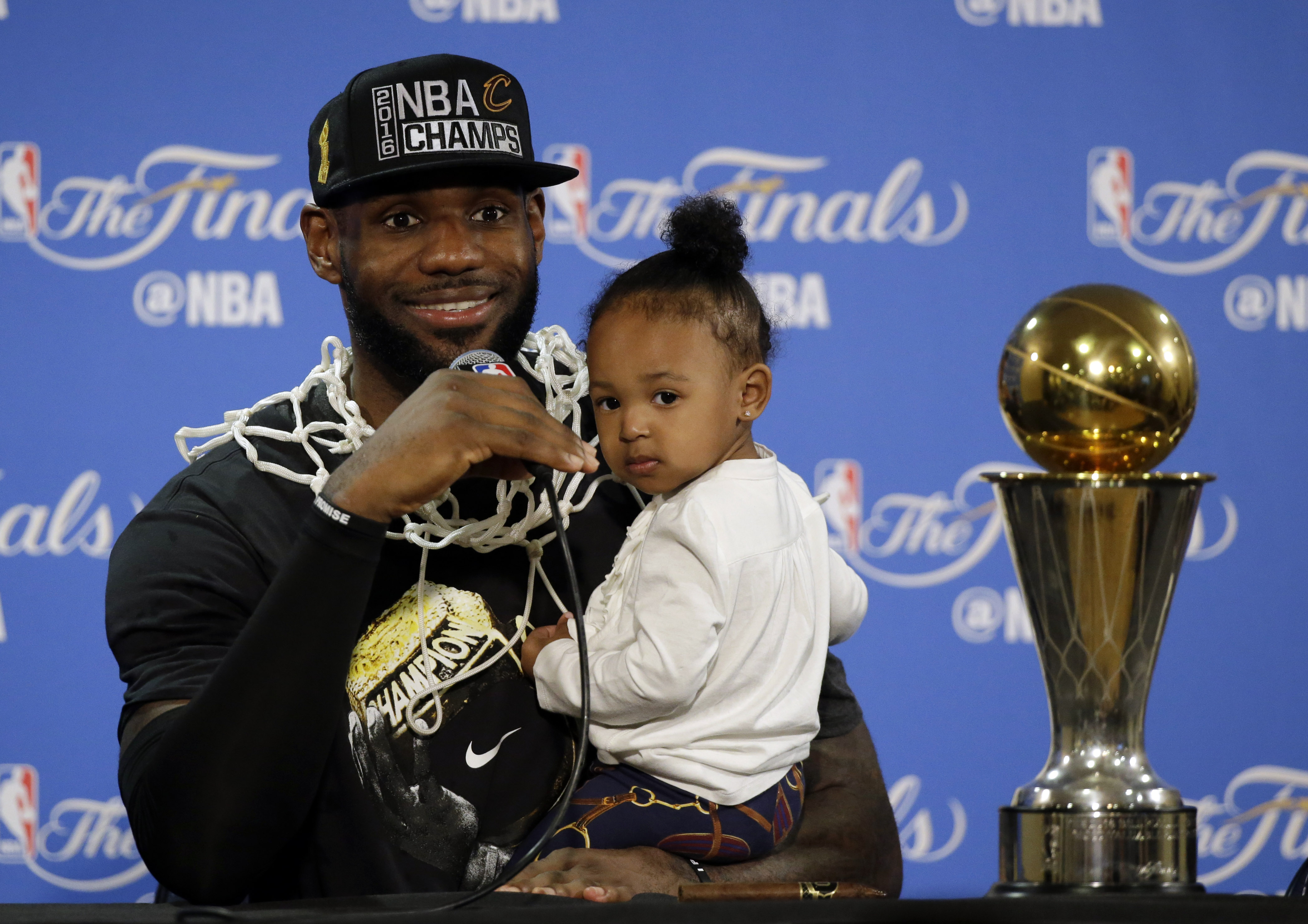 Cleveland Cavaliers' LeBron James answers questions as he holds his daughter Zhuri during a post-game press conference after Game 7 of basketball's NBA Finals Sunday, June 19, 2016, in Oakland, Calif. Cleveland won 93-89. (Photo: AP Photo)