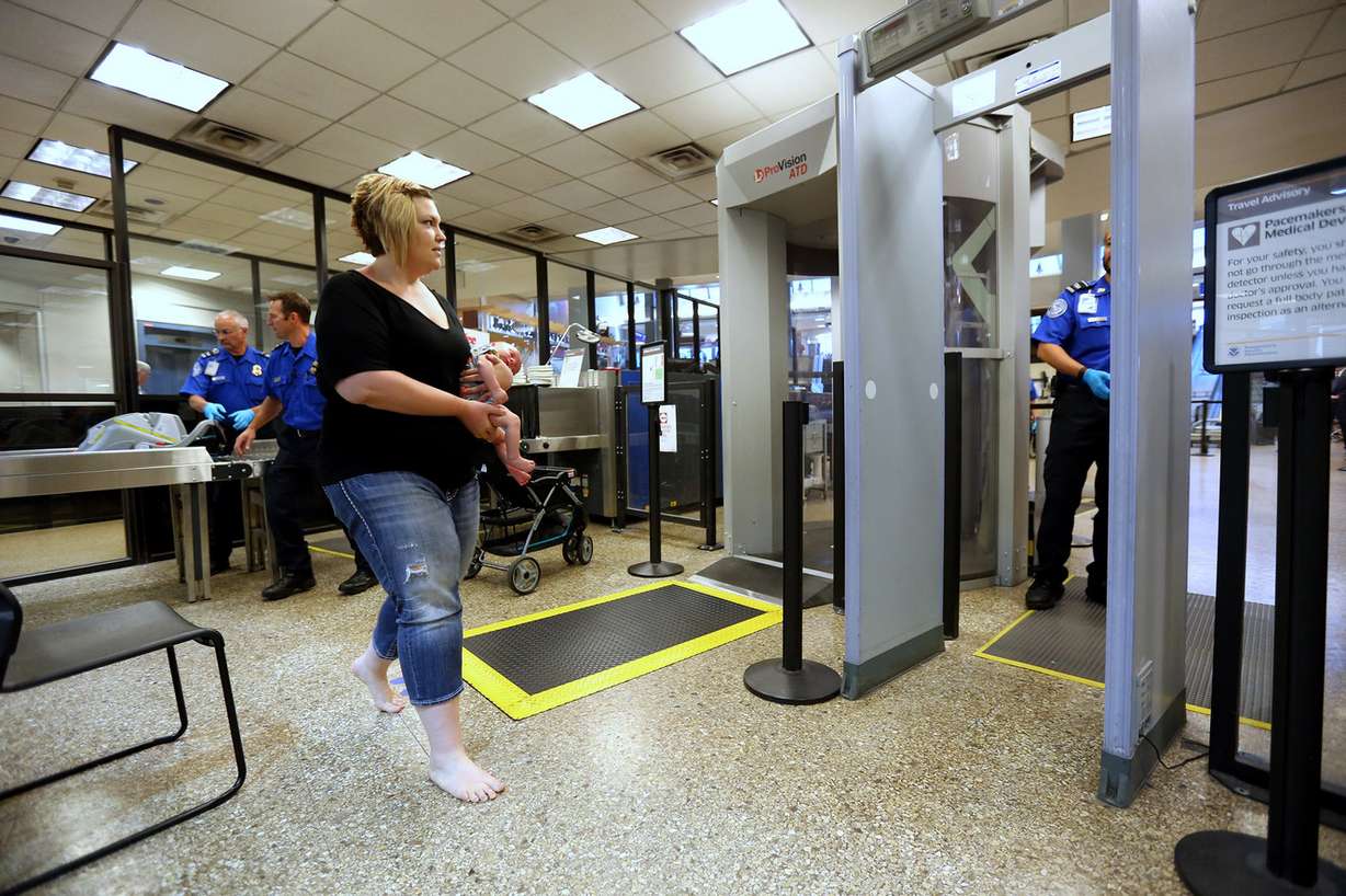 Sabrina Pattillo demonstrates carrying son Bronx Harman through a metal detector during a Transportation Security Administration press event at the Salt Lake City International Airport on Monday, June 20, 2016. During the press event, the TSA offered travel tips for families with infants and children as well as advice on how families can process efficiently through the security checkpoint. (Photo: Scott G Winterton, Deseret News)