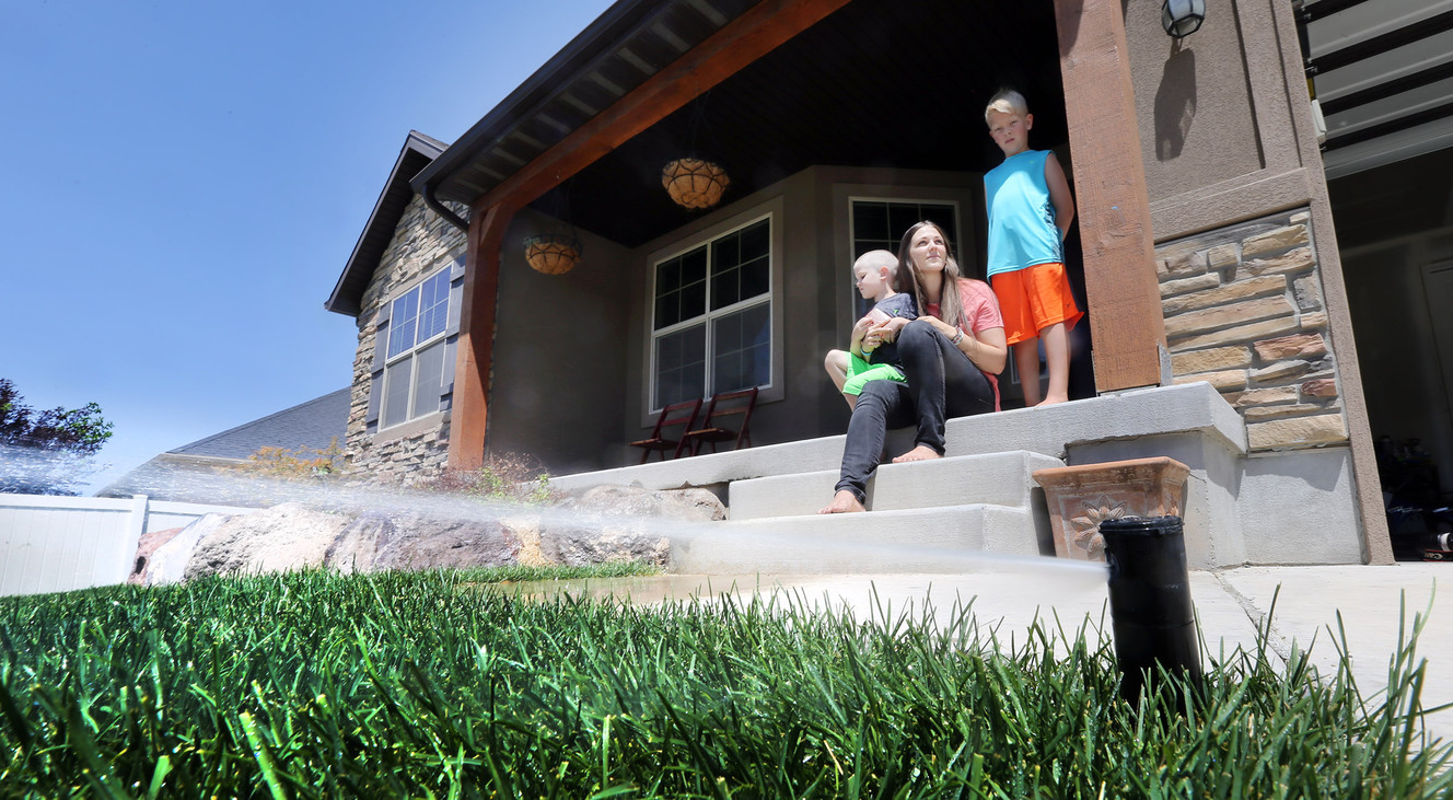 Jillyn Egan, with sons Brock and Howard, discusses Saratoga Springs' irrigation water pressure problems on Tuesday, June 21, 2016. (Photo: Scott G Winterton, Deseret News)