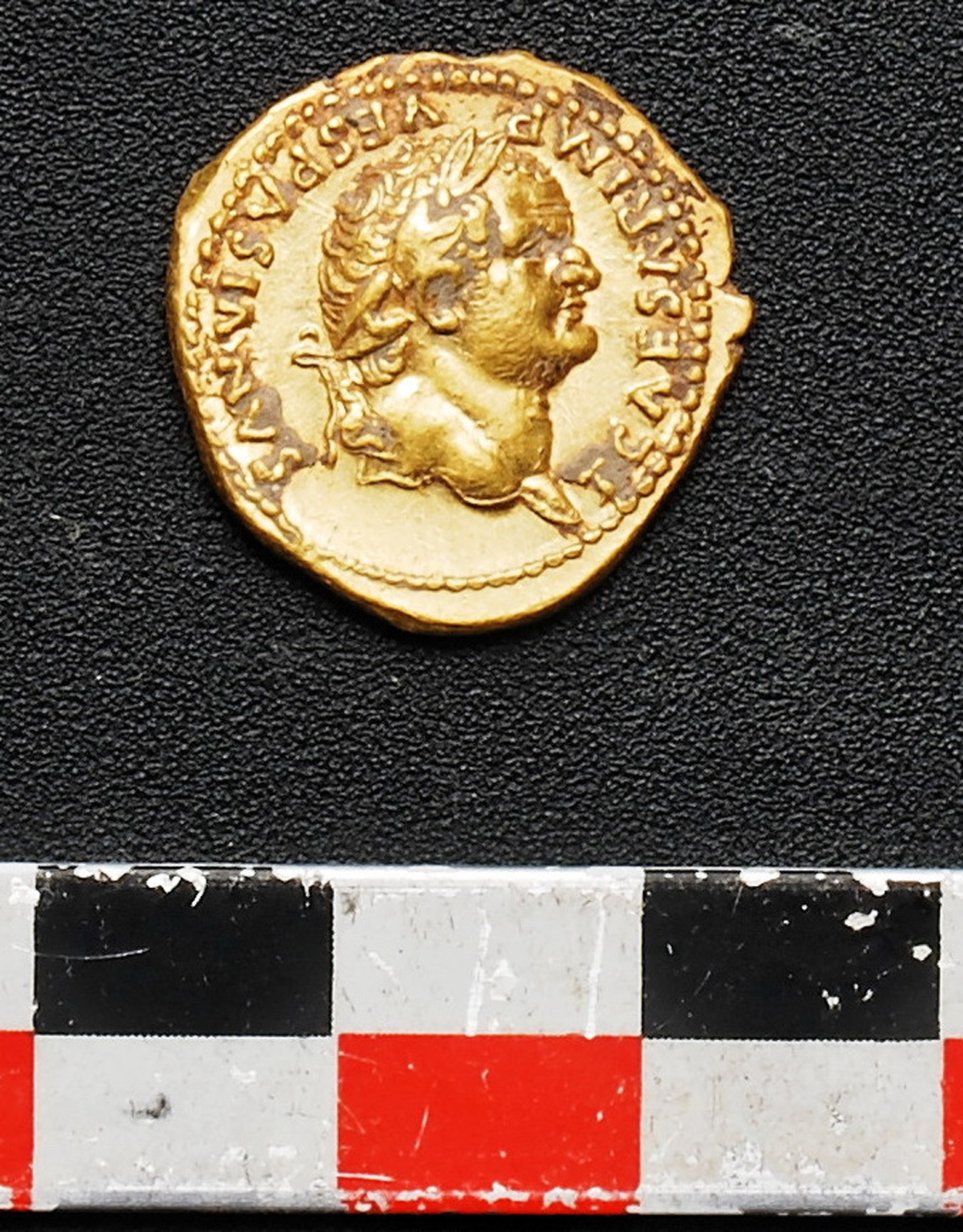 An undated picture made available by the Pompeii Archeological site Press Office, showing a gold coin recently discovered in Pompeii, near Naples, Italy. Italian and French archaeologist team, digging in the outskirts of Pompeii, have discovered four skeletons and gold coins in the ruins of an ancient shop. Pompeii archaeological site officials said Friday, June 24, 2016, the skeletons are those of young people, including an adolescent girl, who perished in the back of the shop when Mount Vesuvius erupted in 79. (Pompeii Archeological Site Press Office via AP)