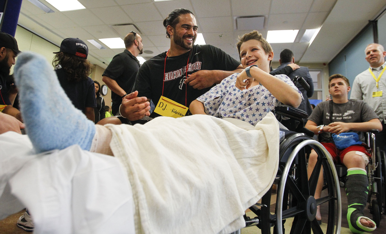 Atlanta Falcons' D.J. Tialavea Tialavea, left, says hello to Colby Bryant, 11, at an event where Utah-based players got to interact with patients at the Primary Children's Hospital in Salt Lake City on Friday, June 24, 2016. (Photo: Weston Kenney, Deseret News)