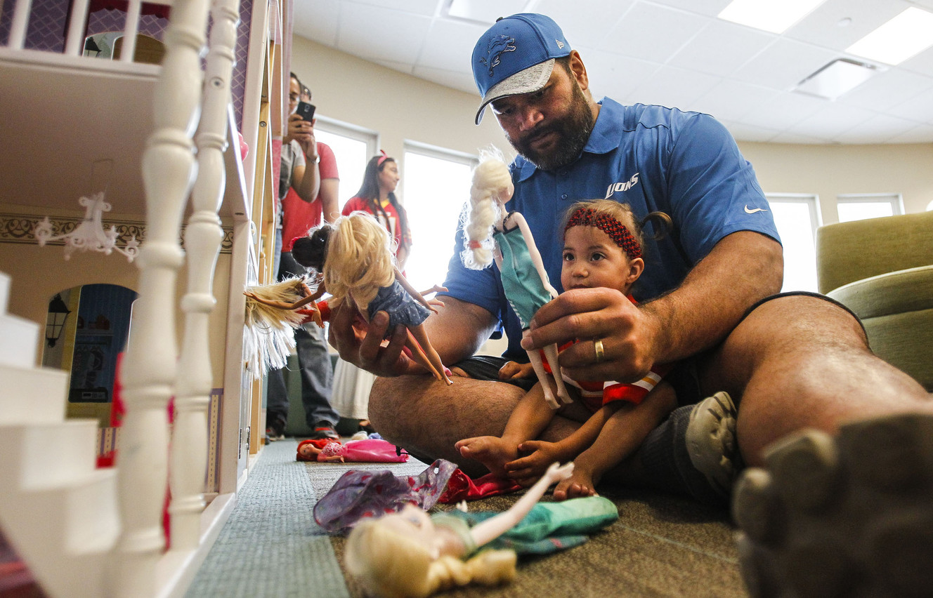 Detroit Lions' Haloti Ngata and Laila Maloney, 2, play with dolls during an event where Utah-based players got to interact with patients at the Primary Children's Hospital in Salt Lake City on Friday, June 24, 2016. (Photo: Weston Kenney, Deseret News