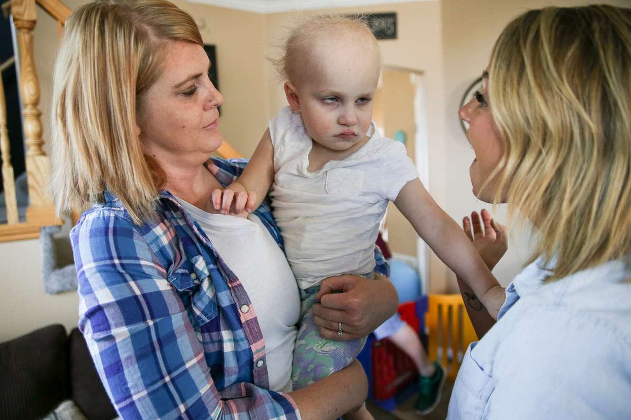 Shelby Morris holds her daughter, Brooklyn, 4, while Brooklyn's preschool teacher, Paige Furbush, right, plays with her at the Morris' home in West Jordan on Thursday, June 23, 2016. Brooklyn has a brain tumor, is mostly blind and suffers from other developmental delays (Photo: Spenser Heaps, Deseret News)