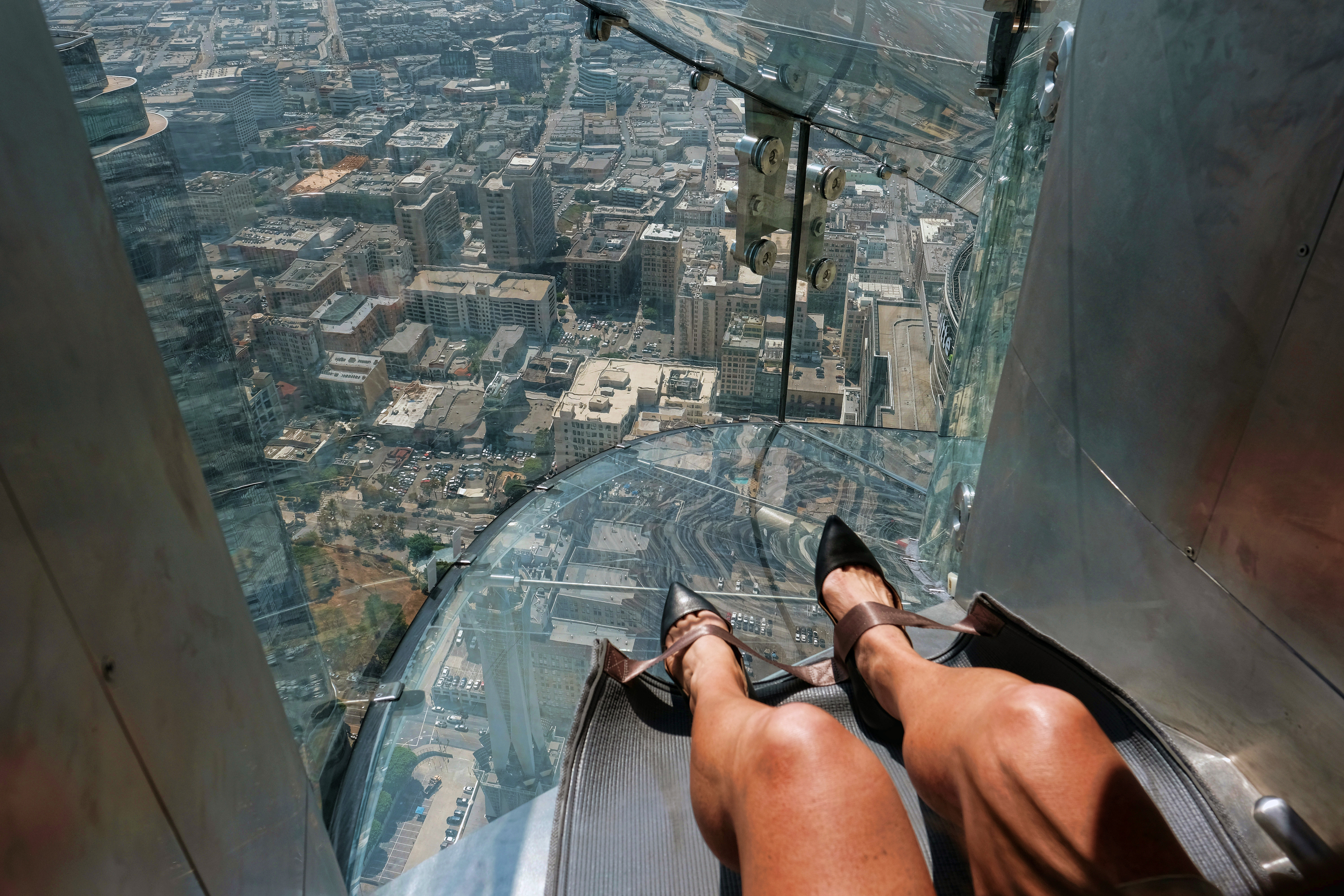 A member of the media takes a ride down a glass slide during a media preview day at the U.S. Bank Tower building in downtown Los Angeles on Thursday, June 23, 2016. All that separates riders from the dizzying space below is a piece of glass just 1¼ inches thick. (AP Photo/Richard Vogel)