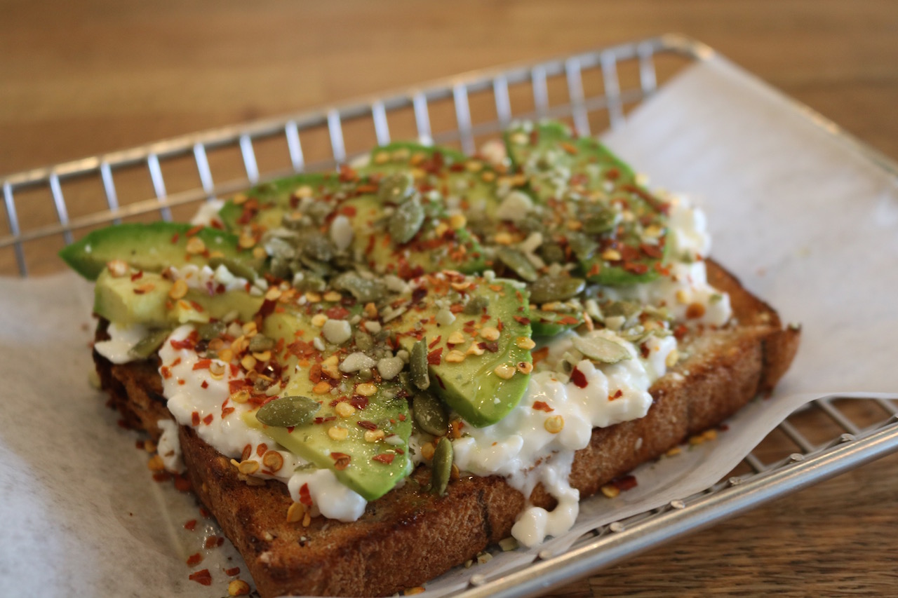 Protein Foundry's Cali Toast with cottage cheese, sliced avocado, olive oil, chili pepper flakes, sea salt and crushed pepitas. (Photo: Emi Rigby, welltraveledwife.com)