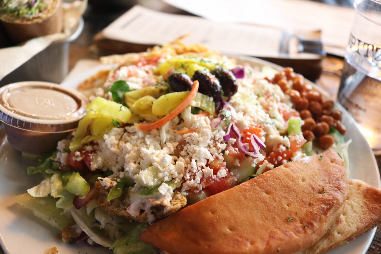 The döner salad from Spitz SLC filled with romaine, cabbage, carrot, onion, green pepper, cucumber, olives, feta, pepperoncinis, tomato, tzatziki, fried lavash chips, crispy garbonzo, fried pita, chicken and a side of balsamic dressing, (Photo: Emi Rigby, welltraveledwife.com)