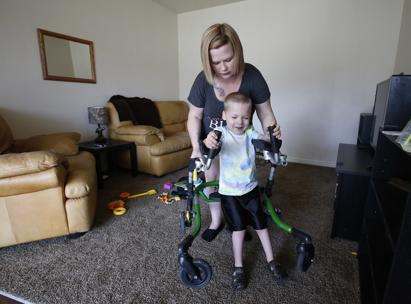 Rosy Mintz watches over her son, Keaton, as he uses his walker in their home in Tooele on Sunday, July 3, 2016. Their car was stolen along with a portion of Keaton's wheelchair. (Photo: Jeffrey D. Allred, Deseret News)