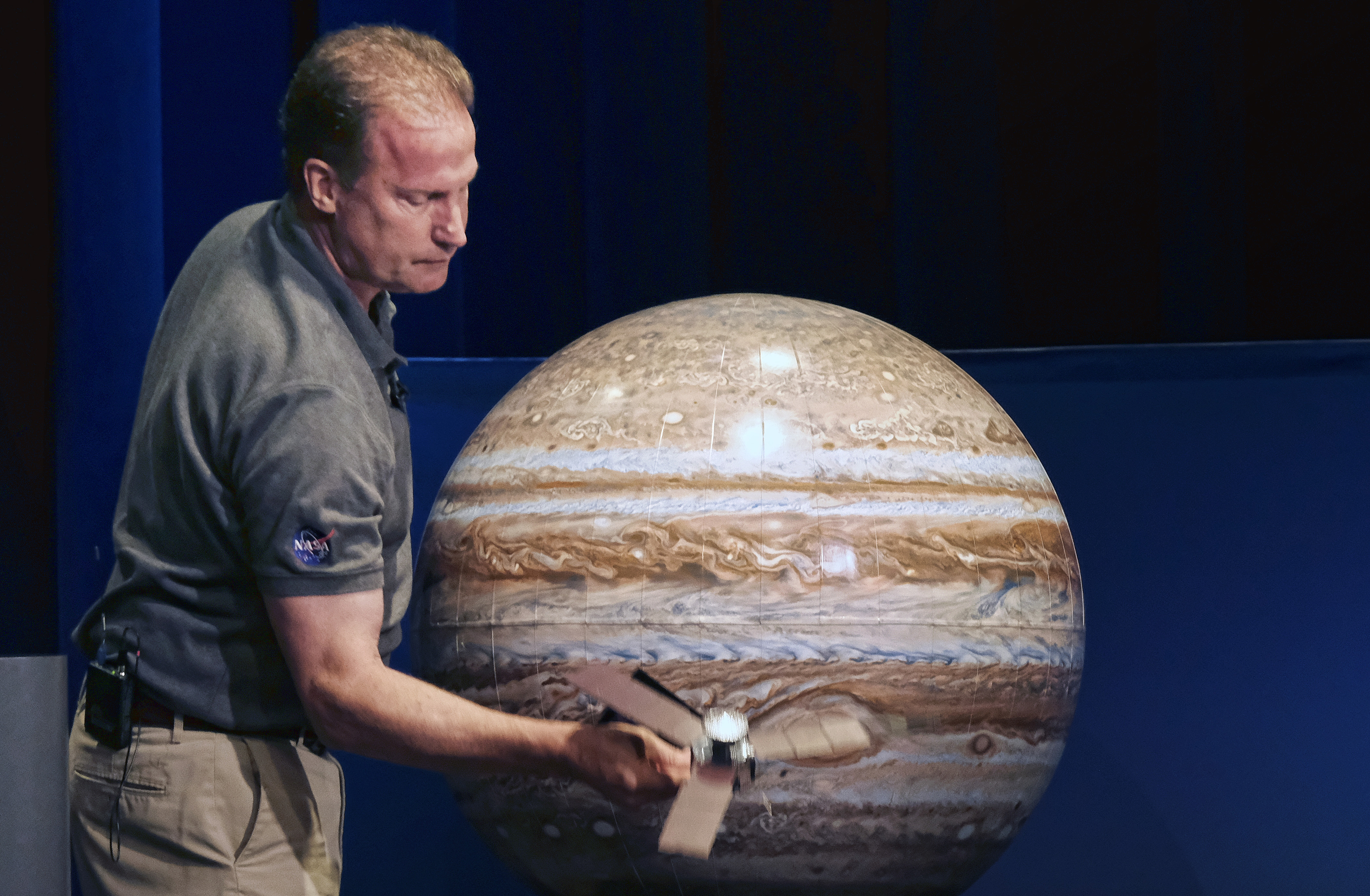 Rick Nybakken, Juno Project Manager, holds a model of the Juno spacecraft discusses the orbit the Juno spacecraft will take around Jupiter during a briefing at the Jet Propulsion Laboratory in Pasadena, on Monday, July 4, 2016. The solar-powered spacecraft is on it's way toward Jupiter for the closest encounter with the biggest planet in our solar system. NASA's Juno spacecraft will fire its main rocket engine late Monday to slow itself down from a speed of 150,000 mph (250,000 kph) and slip into orbit around Jupiter. (AP Photo/Richard Vogel)