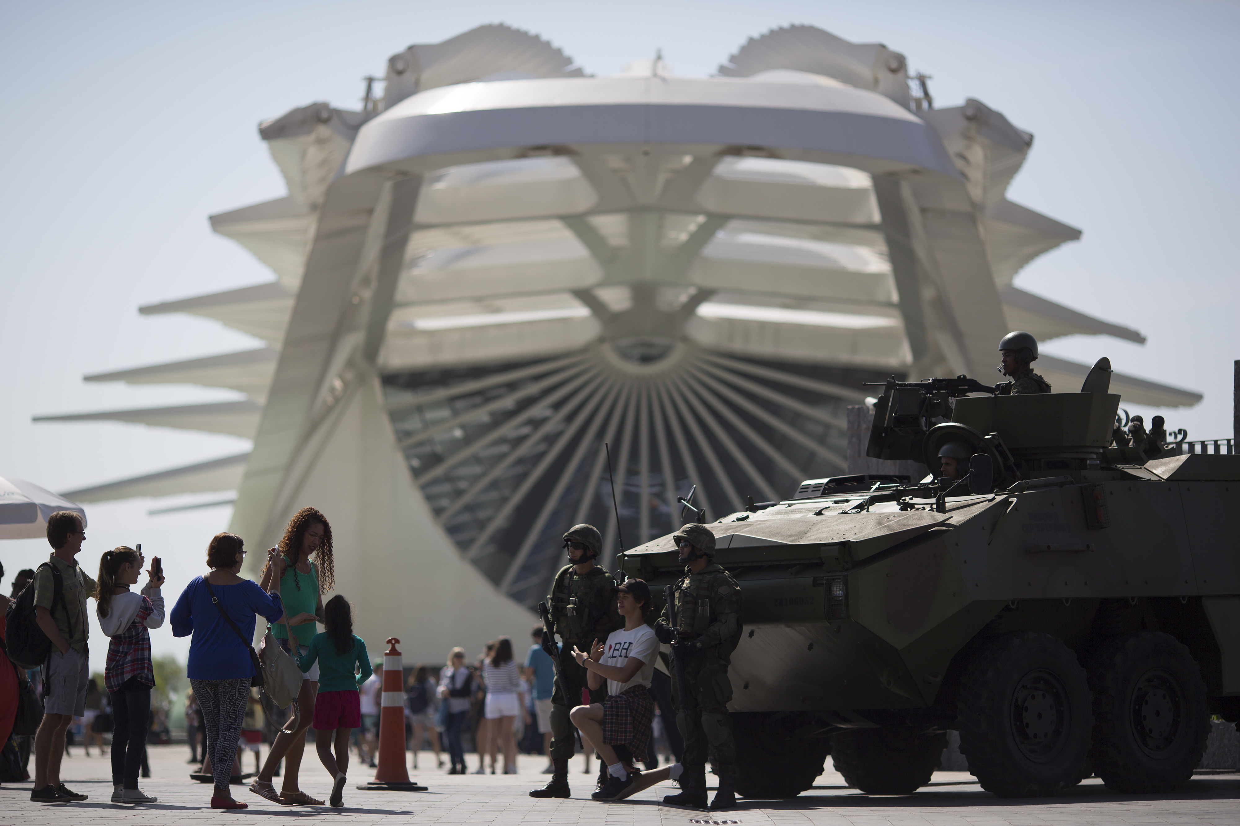 People take pictures with marines and their armored vehicle outside the Museum of Tomorrow in Rio de Janeiro, Brazil, Saturday, July 9, 2016. Roughly twice the security contingent at the London Olympics will be deployed during the August games in Rio, which are expected to draw thousands of foreigners to a city where armed muggings, stray bullets and turf wars between heavily armed drug gangs are routine. (AP Photo/Leo Correa)