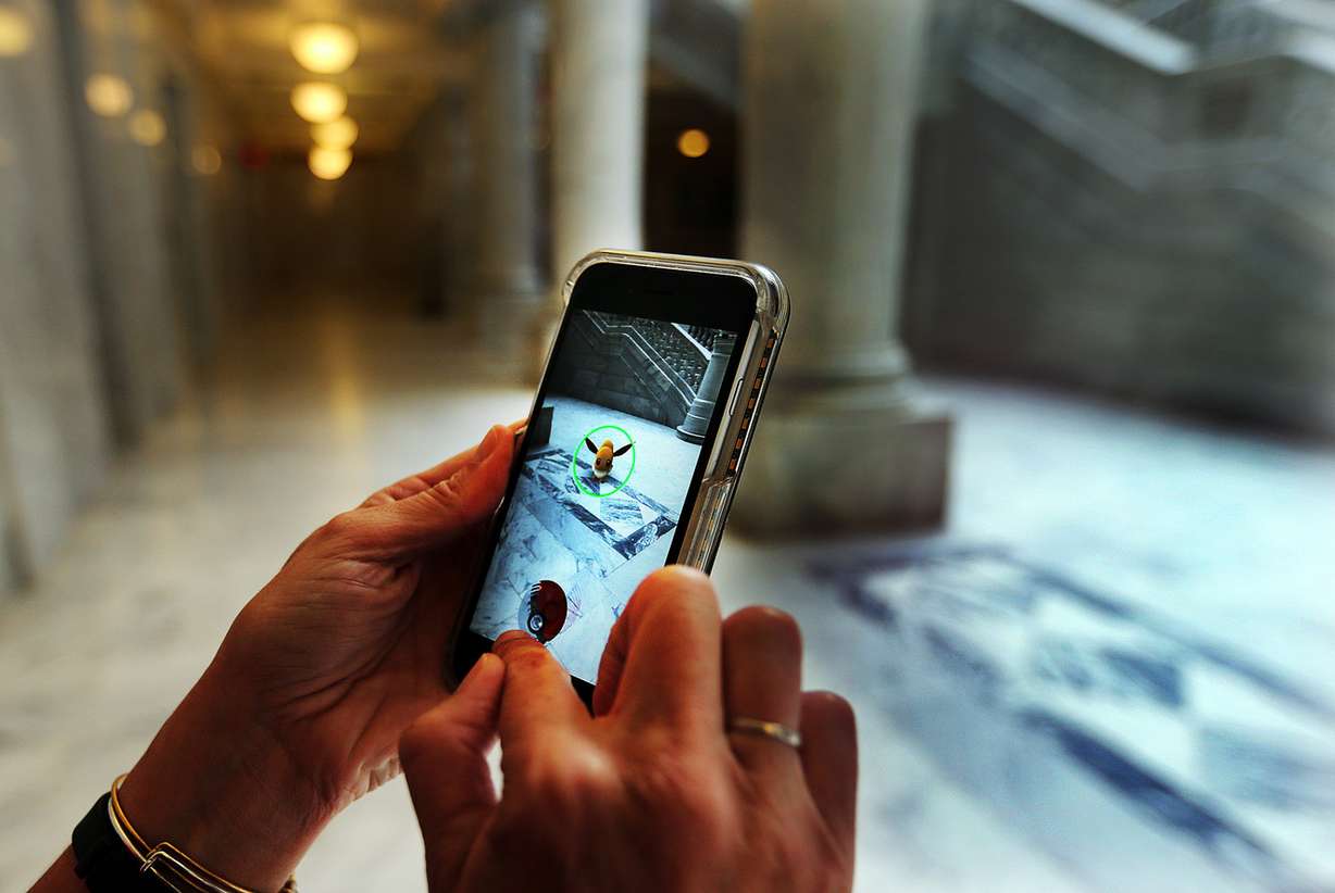 Jenn Storie catches an Eevee as she plays Pokemon Go during a break from work at the Capitol in Salt Lake City on Monday, July 11, 2016. (Photo: Ravell Call, Deseret News)