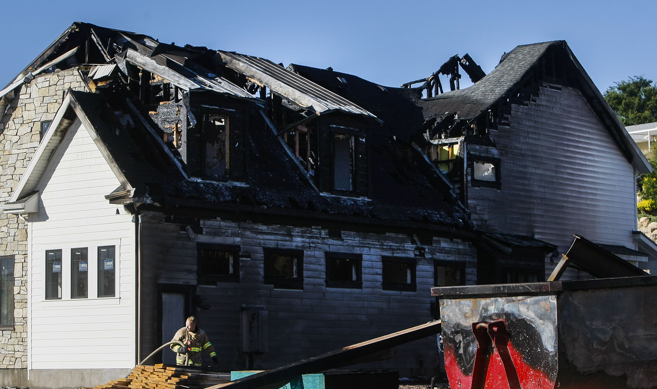 A South Jordan firefighter responds to a house fire on Tuesday, July 12, 2016, that destroyed two newly built homes at Lazy Water Cove. The fire occurred late Monday night. (Photo: Weston Kenney, Deseret News)