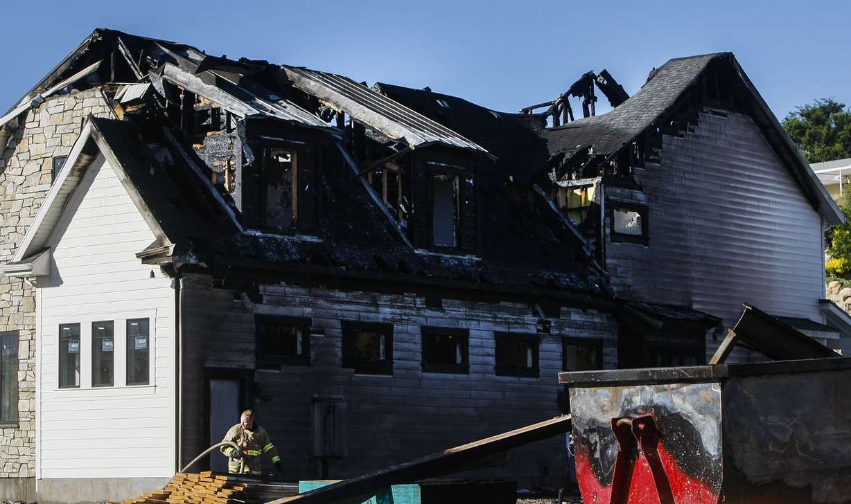 A South Jordan firefighter responds to a house fire on Tuesday, July 12, 2016, that destroyed two newly built homes at Lazy Water Cove. The fire occurred late Monday night. (Photo: Weston Kenney, Deseret News)