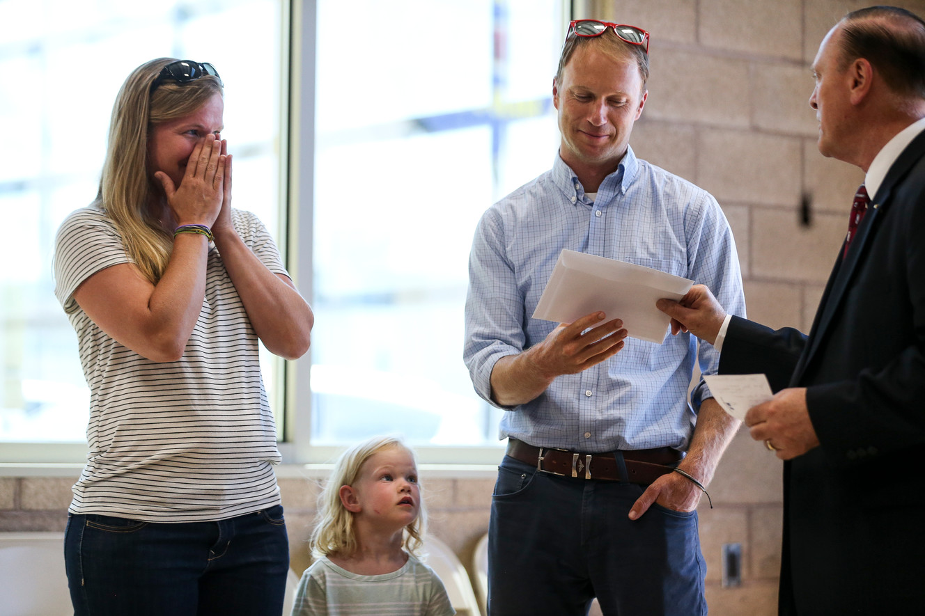 Ali and Mark Thackeray and their daughter, Ruby, 3, react as they are presented with an envelope containing a cash donation, along with a free car, at Martins Collision Repair in Orem on Wednesday, July 20, 2016. (Photo: Spenser Heaps, Deseret News)
