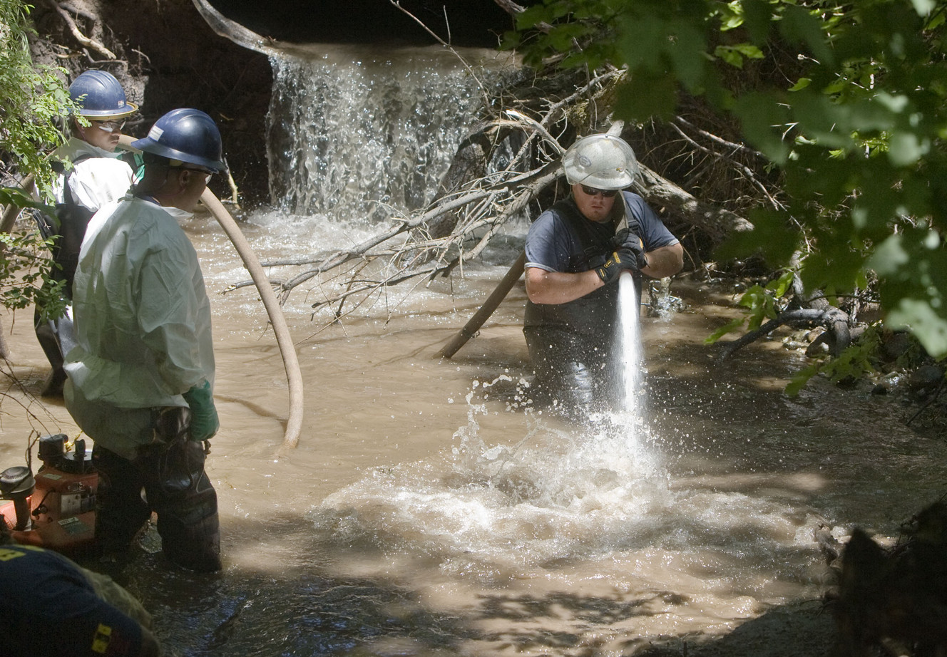 Members of the Red Butte Canyon Spill Unified Command Cleanup Operation crew uses a fire float to wash the bank of Red Butte Creek behind the Veterans Medical Center in Salt Lake City on June 28, 2010. Six years after a ruptured pipeline sent 800 barrels of oil into the creek, Chevron says it is as clean as other urban waterways and water quality monitoring should cease. (Photo: Deseret News Archives)