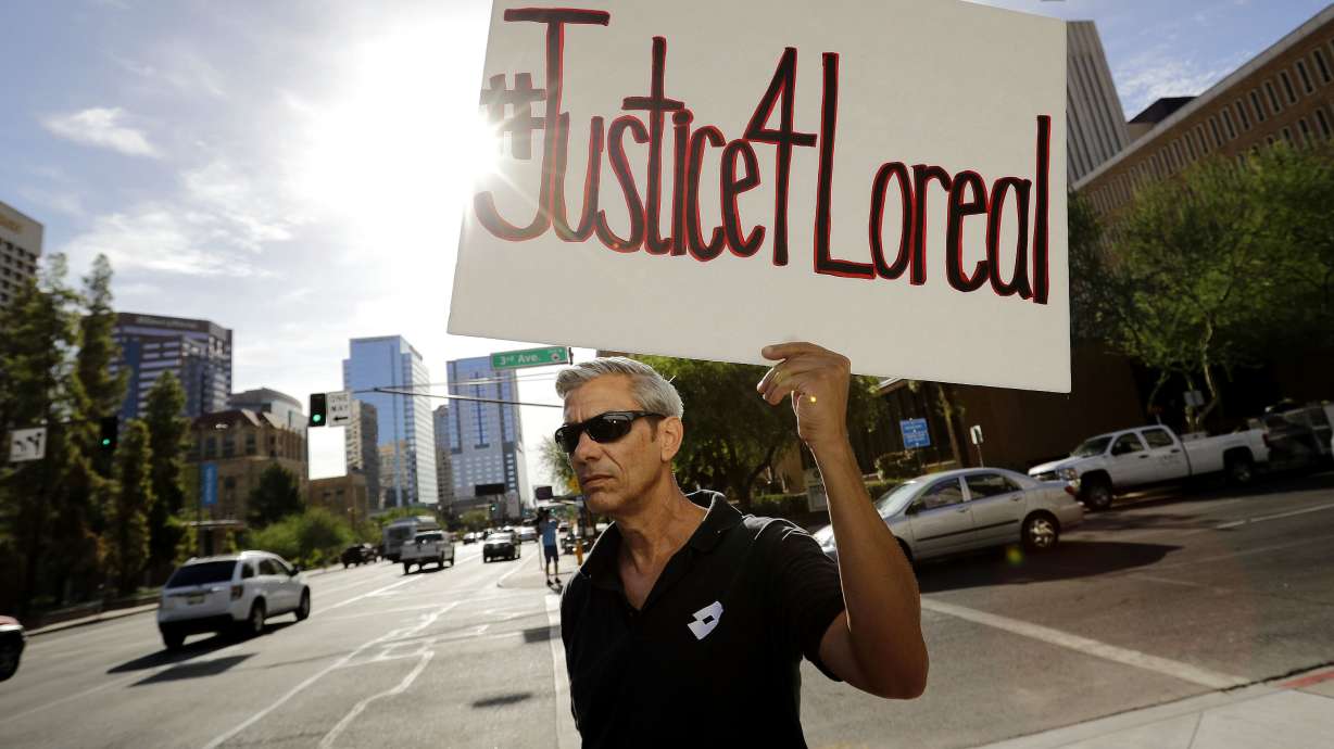 Chris Fleischman protests outside Maricopa County Attorney Bill Montgomery's office in Phoenix, July 25, 2016. Loreal Tsingine was a Navajo woman who was fatally shot by an Arizona police officer.