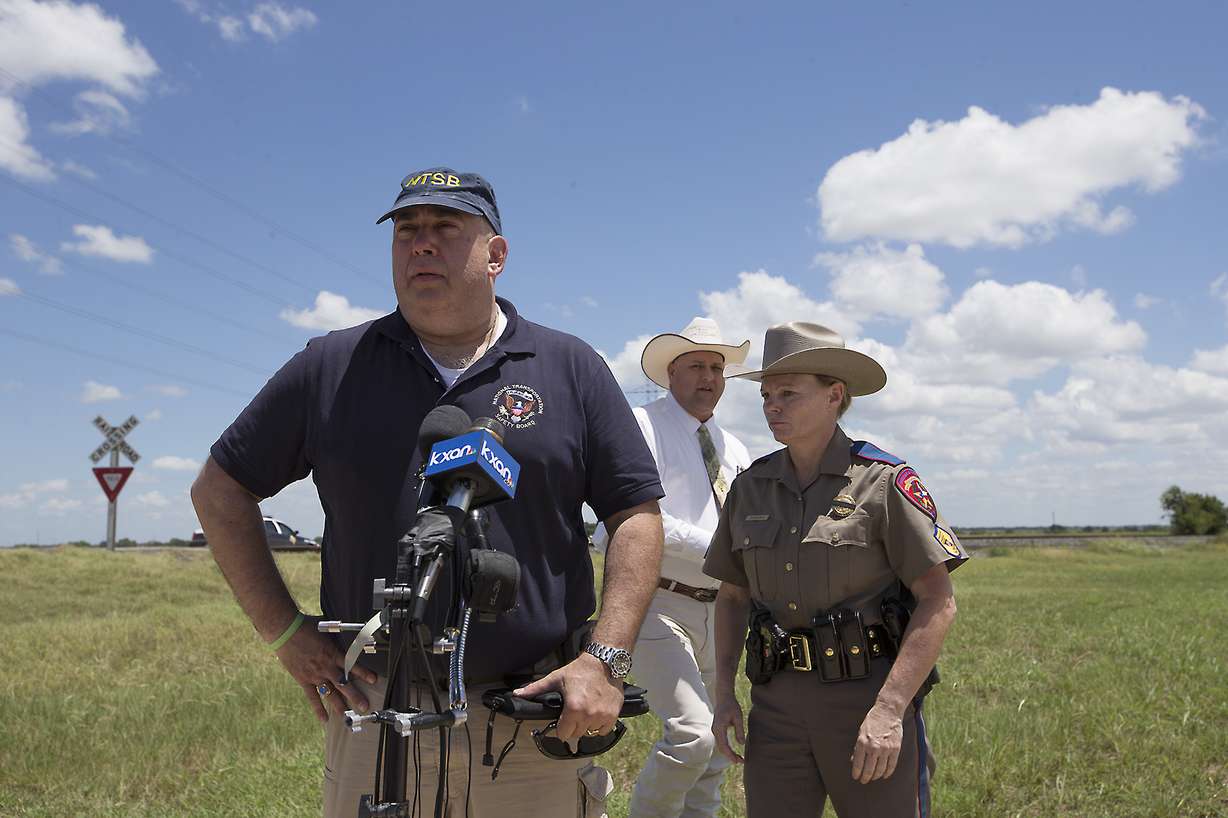 National Transportation Safety Board Senior Advisor Erik Grosof, left, Caldwell County Sheriff Daniel Law and Texas DPS Trooper Robbie Barrera, right, leave the scene of a hot air balloon disaster Saturday, July 30, 2016, near Lockhart, Texas, causing what authorities described as a "significant loss of life." (Ralph Barrera/Austin American-Statesman via AP)
