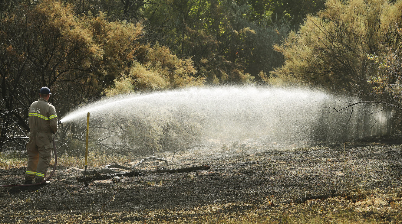 Firefighters work on a grass fire on the Jordan River Parkway Trail near the Oxbow Jail in Salt Lake City on Sunday, July 31, 2016. (Photo: Jeffrey D. Allred, Deseret News)