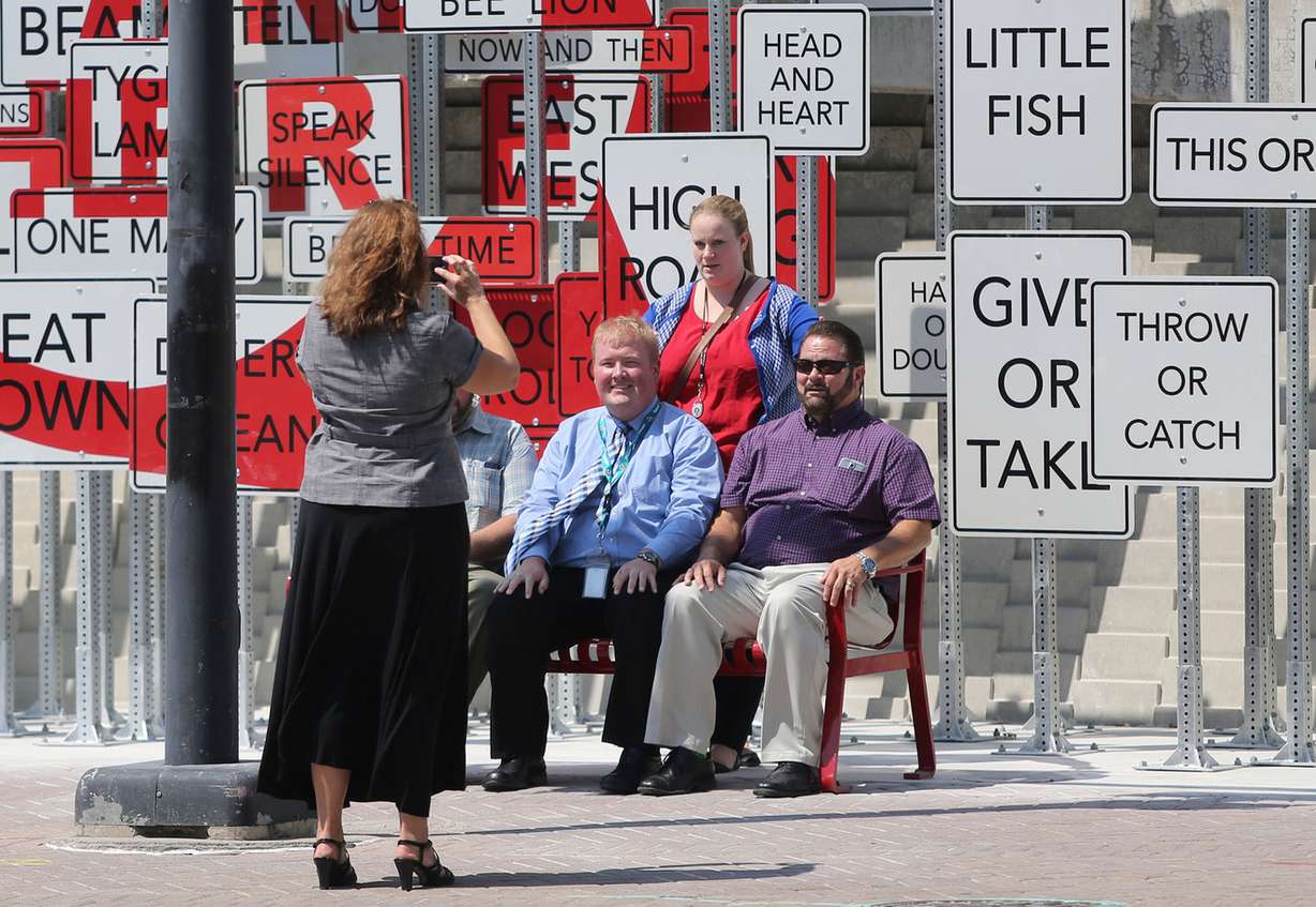 Jennifer Evans takes a photo of Thomas Riley, Mariah Hill and Bob Spohr in front of Point of View, the new art installation in front of the Salt Palace Convention Center in Salt Lake City on Thursday, Aug. 4, 2016. (Photo: Kristin Murphy, Deseret News)