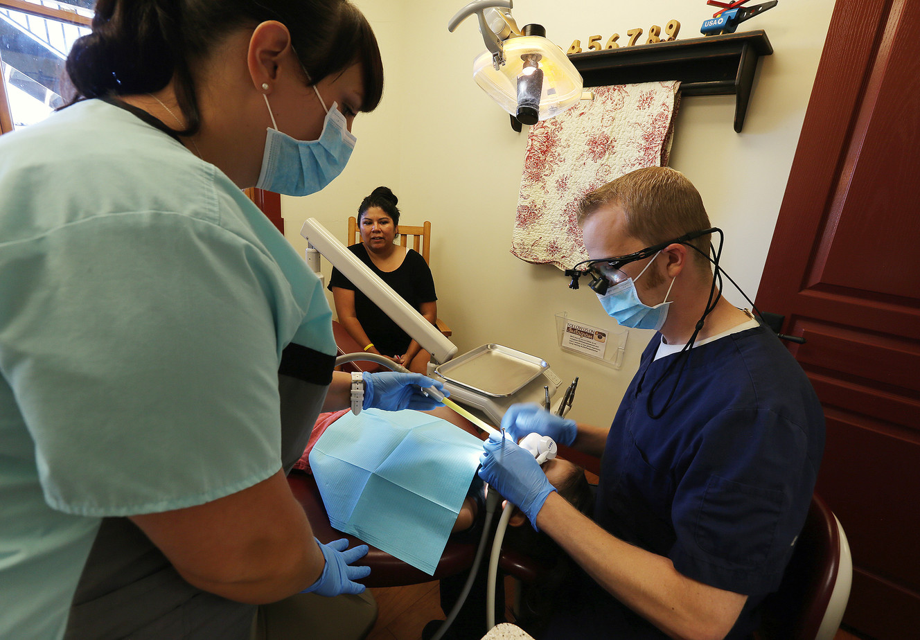 Dr. Thayne Gardner and dental assistant Kristin Olsen work on 3-year-old Preslee Erickson's teeth as her mother, Utahna, watches at Little People's Dental in South Jordan on Friday, Aug. 12, 2016. (Photo: Scott G Winterton, Deseret News)