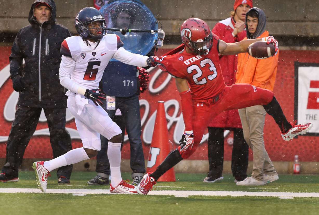 Utah Utes running back Devontae Booker (23) is held back by Arizona Wildcats cornerback Jonathan McKnight (6) as the University of Utah is defeated by Arizona University 42-10 in PAC 12 football in Rice-Eccles Stadium Saturday, Nov. 22, 2014, in Salt Lake City. (Photo: Tom Smart, Deseret News)