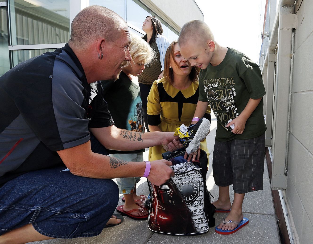 Jason McCowen helps his son, Daniel, look through a backpack of school clothing given to Daniel at the Road Home in Midvale on Thursday, Aug. 18, 2016. Back-to-school clothing was given to 150 children in time for the first day of school. (Photo: Ravell Call, Deseret News)