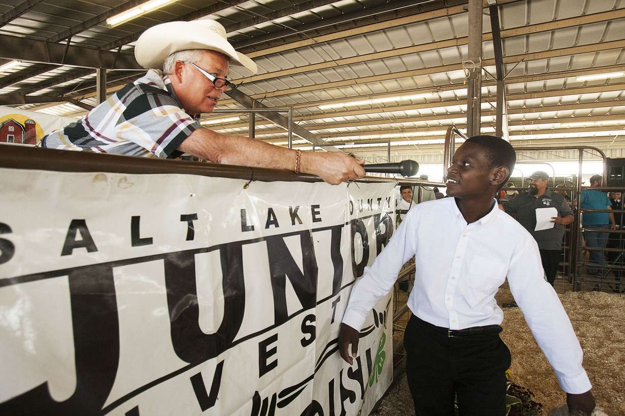 Auctioneer Dee Oakeson asks Elias Maniocambona how to pronounce his last name at the Salt Lake County Fair in South Jordan on Saturday, Aug. 20, 2016. (Photo: Hans Koepsell, Deseret News)