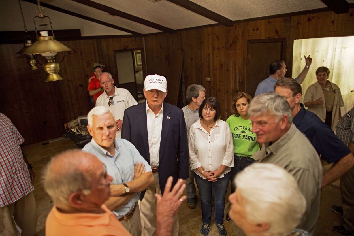 Republican presidential candidate Donald Trump, center, and his running mate, Indiana Gov. Mike Pence, listens to flood victims Jimmy and Olive Gordan during a tour of their flood damaged home in Denham Springs, La., Friday, Aug. 19, 2016. (Max Becherer, AP Photo)