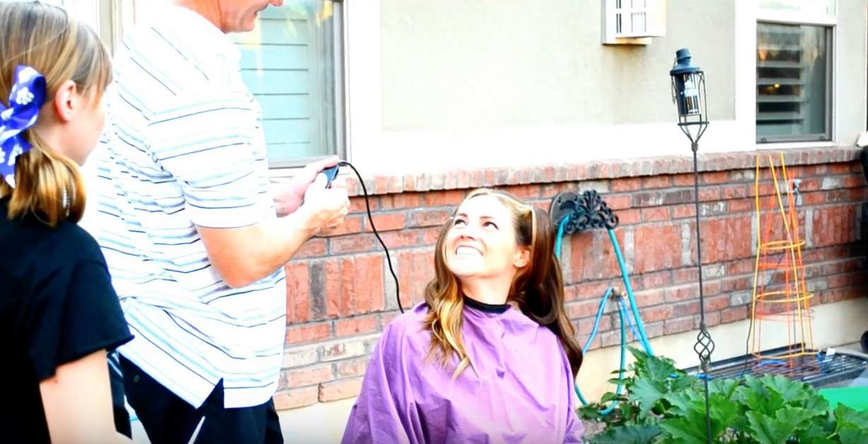 Sara Hill has her head shaved by her husband, Weber State football coach Jay Hill, before undergoing treatment for Hodgkin's lymphona. (Photo: YouTube)