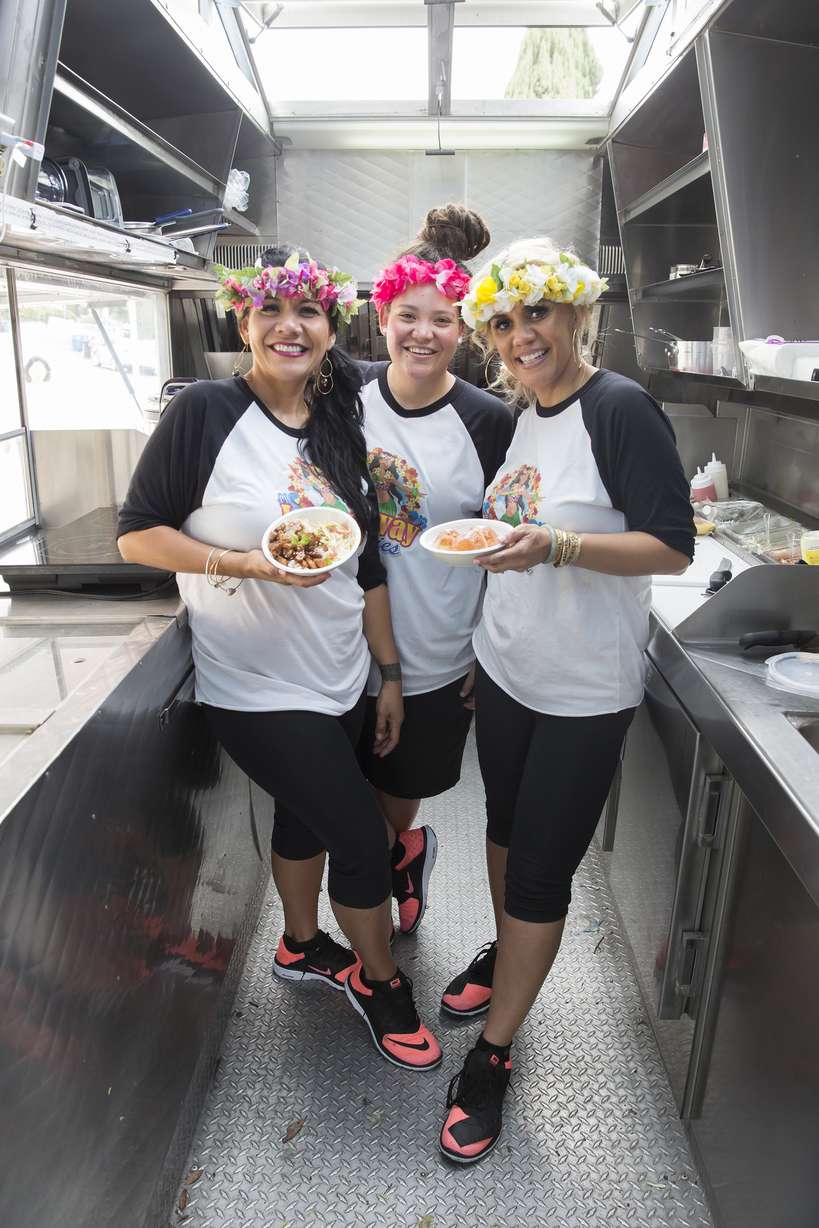 The Lei-Away Leidies pose with two of their signature dishes, the 'Poke Bowl' and the 'Maui Wowie,' in their food truck. (Food Network)