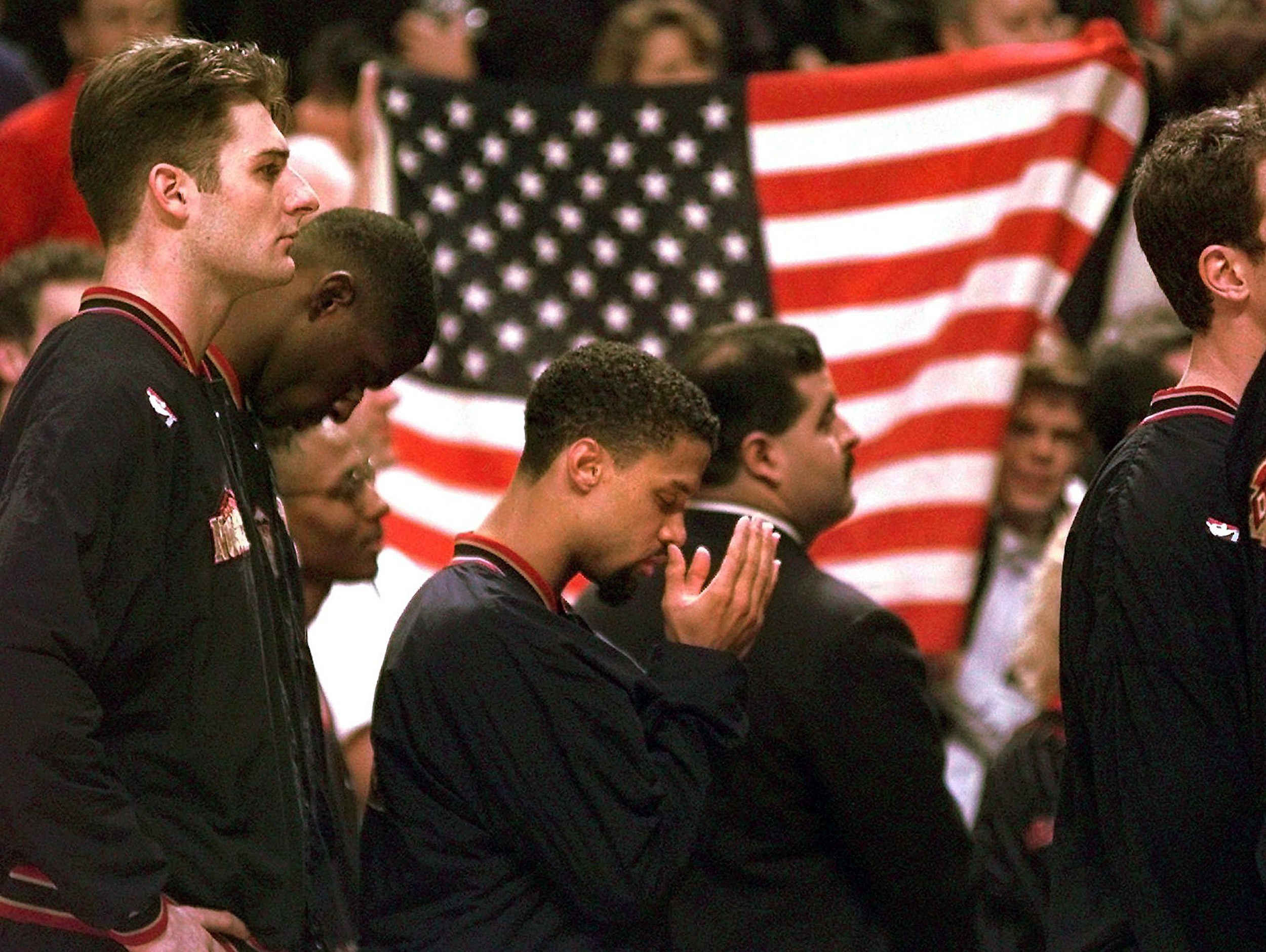FILE - In this March 15, 1996 file photo, Denver Nuggets guard Mahmoud Abdul-Rauf stands with his teammates and prays during the national anthem before an NBA basketball game against the Chicago Bulls in Chicago. This was Abdul-Rauf's first game back since he was suspended by the NBA on March 12, 1996, for refusing to participate in the national anthem pre-game ceremony. (M. Spencer Green, AP Photo, File)